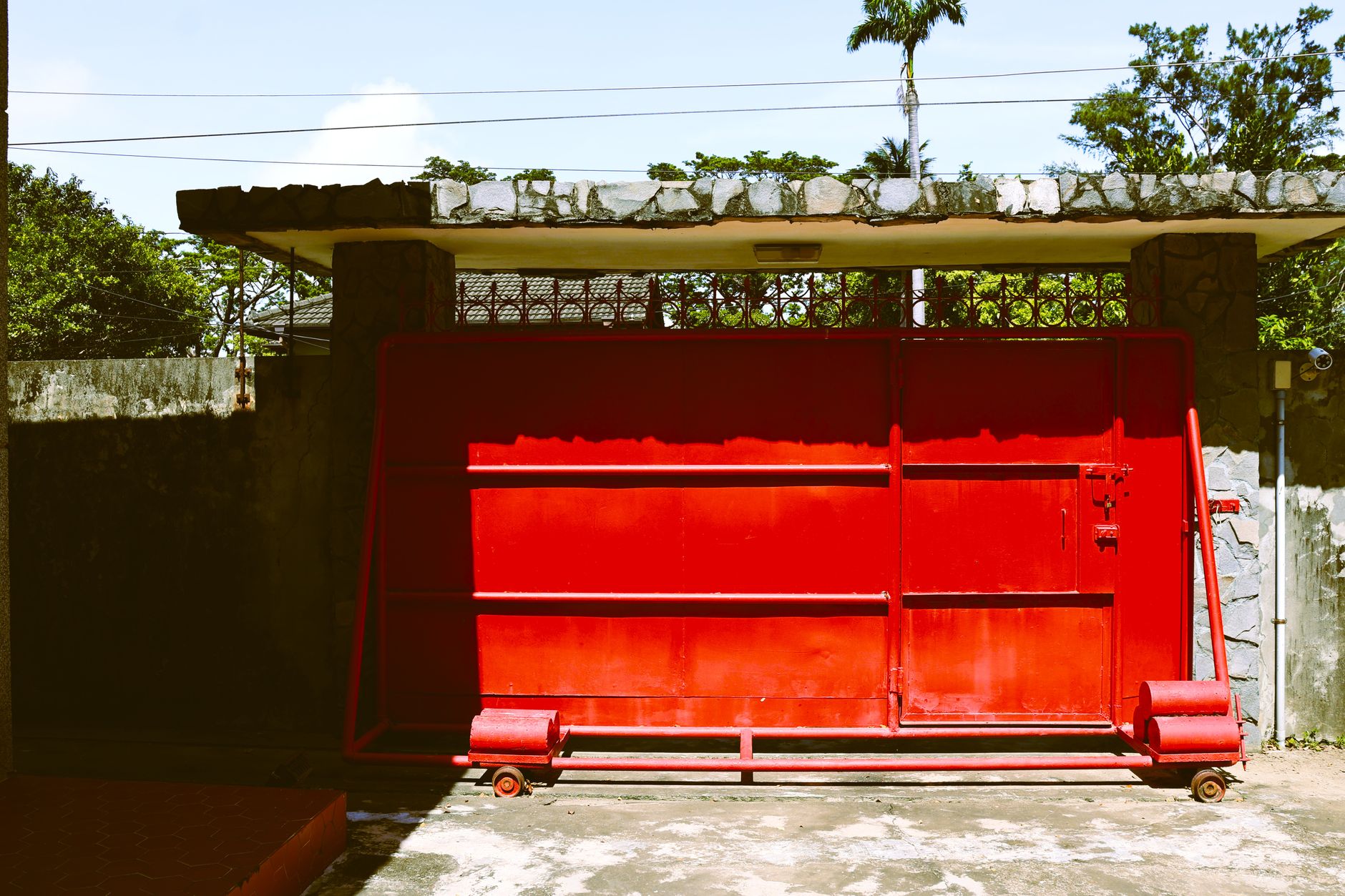 A vibrant red gate in an urban area of Kaohsiung, featuring modern and vintage contrasts